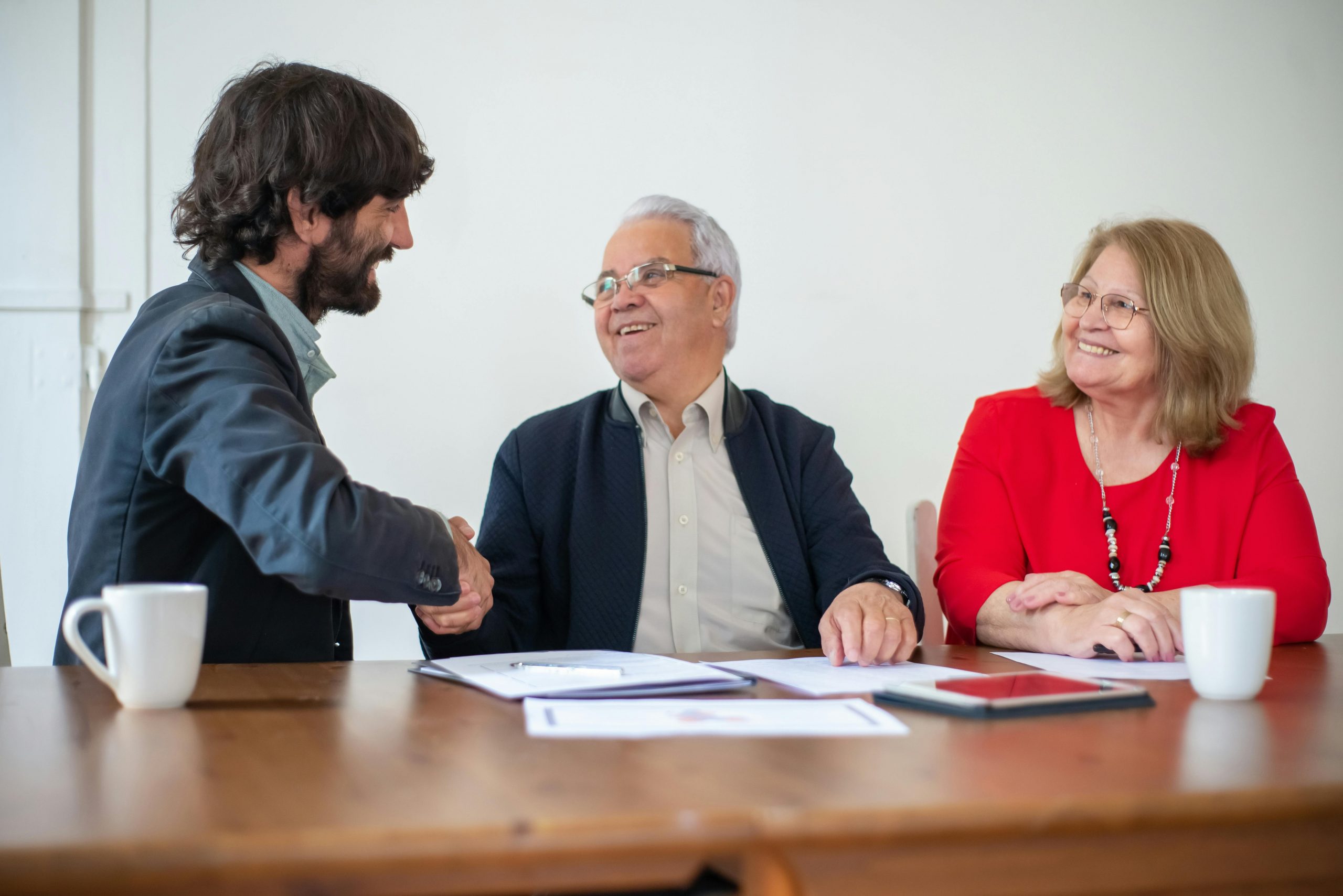 Elderly professionals having a joyful business meeting, shaking hands and smiling